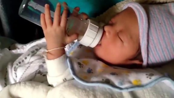 小宝宝睡梦中抱着奶瓶喝奶，都喝没有了还舍不得放手！